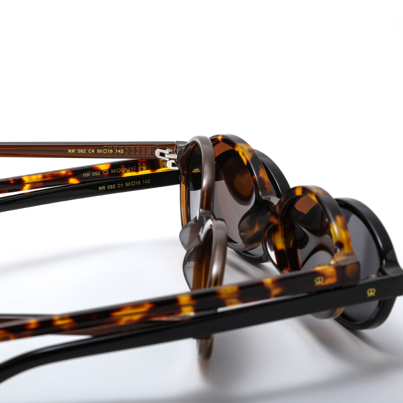 Trendy, oval, acetate frame and temples, in shiny black color with dark smoke polarized lenses for 100% UV protection.